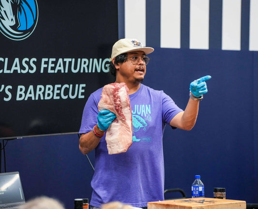 Pitmaster Joe Zavala teaching with a brisket at a Zavala's Barbecue class